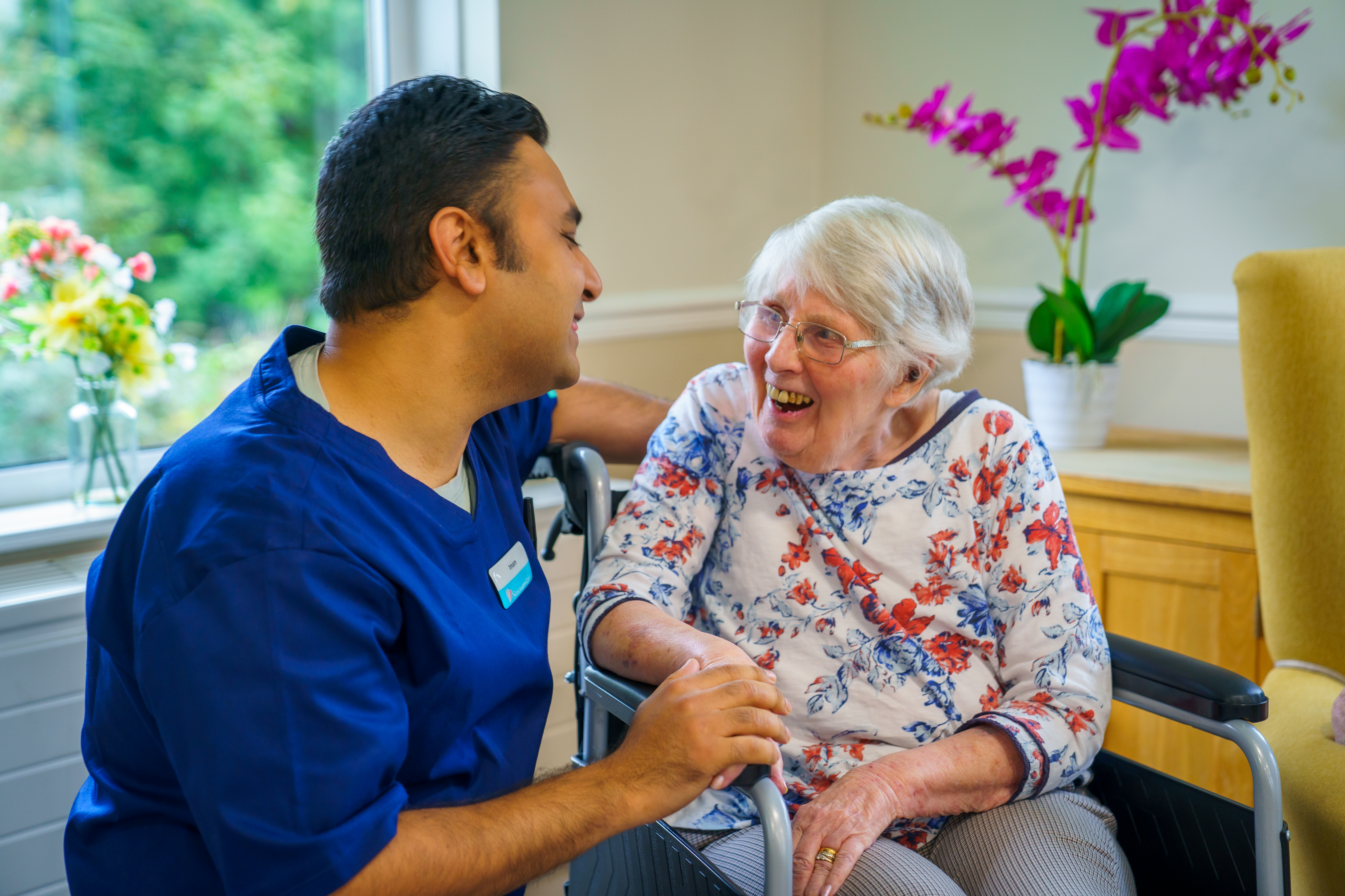 A female resident laughing with a member of staff