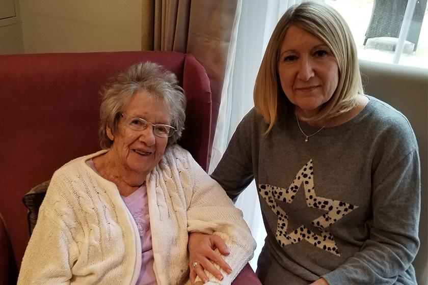 Mother and Daughter seated smiling 