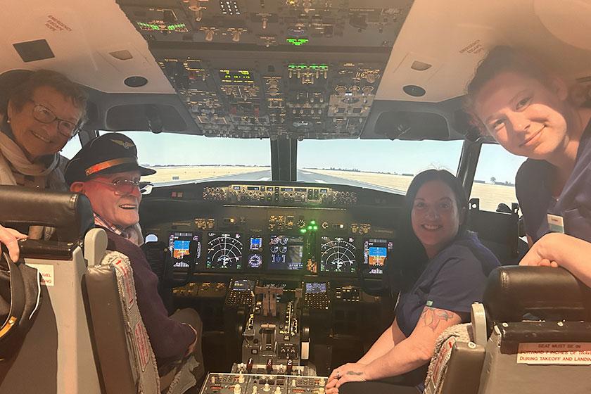 David Auld beams with joy as he enjoys a flight simulator experience with wife Jean and two staff from Queens Care Home in South Ayrshire 