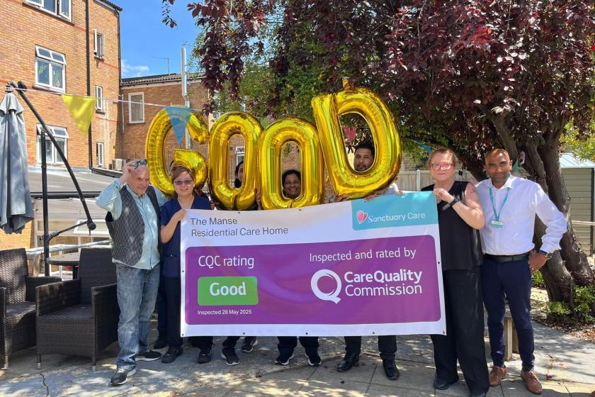 A group of six people stands outside a residential care home, holding large gold balloons that spell out "Good." They are gathered around a banner that reads "The Manse Residential Care Home," along with the CQC rating and inspection details. The setting features greenery and a sunny atmosphere, indicating a positive environment.