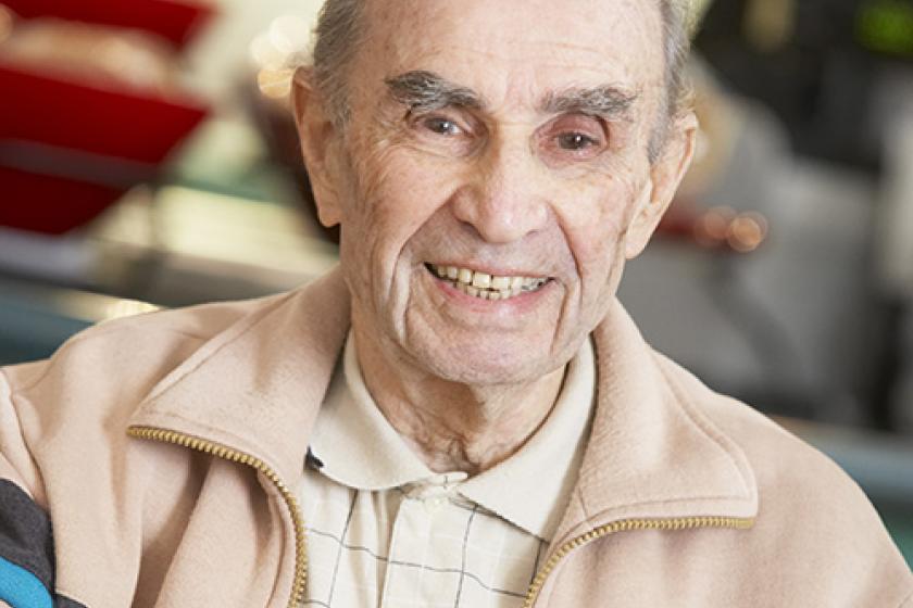 Senior man smiling as he drinks a cup of coffee