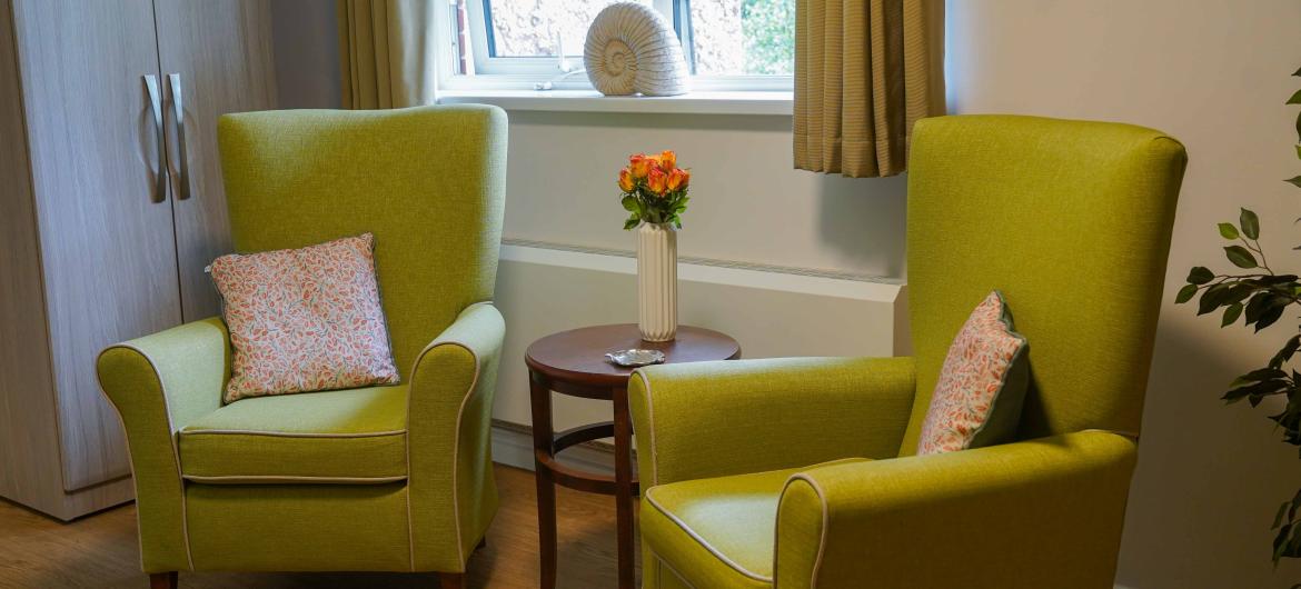 Two green armchairs next to each other in a cosy room