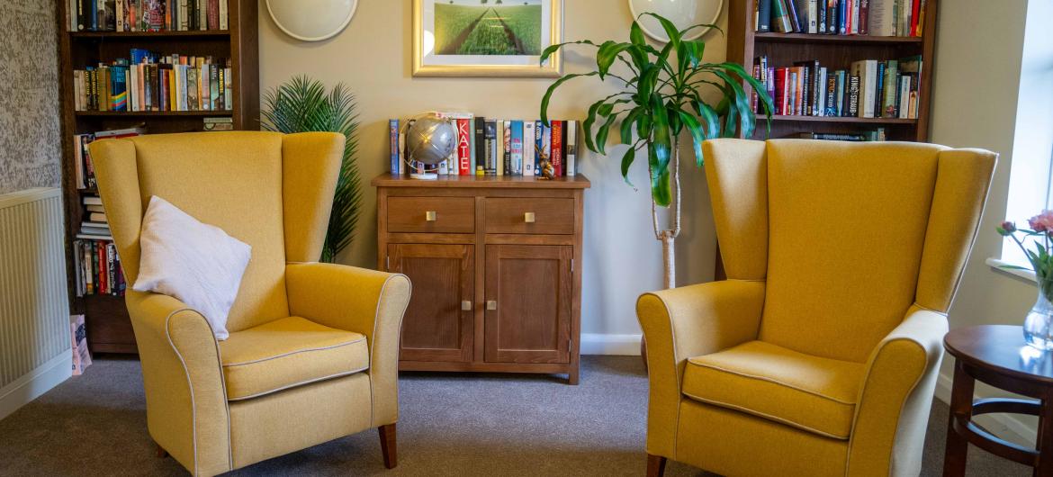 Two yellow chairs in a room with bookshelves