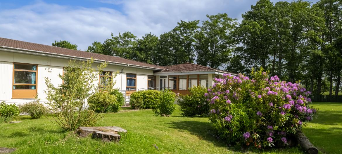 Landscape photo of the garden and exterior of Mull Hall Care Home in Invergordon.