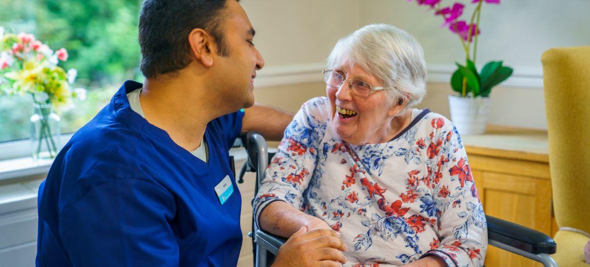 Sanctuary Care employee MD Bakhtear Imam talking and smiling with resident Maureen