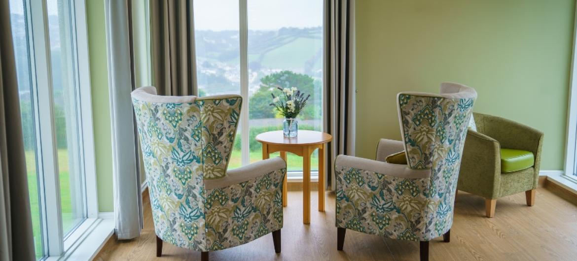 Comfortable armchairs pointed towards the large window with a spectacular view