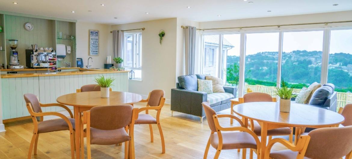 A large dining area with floor to ceiling windows showing an incredible view