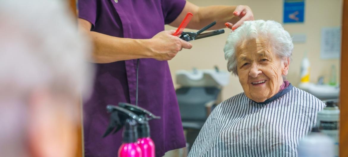 A female resident having her hair cut in the hair salon