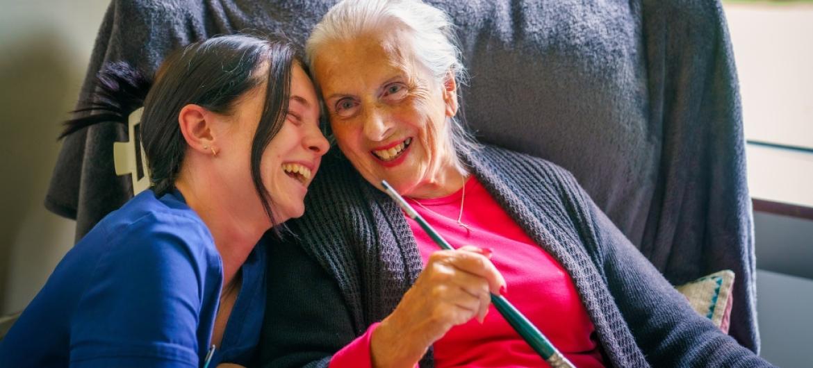 A resident and SSL member of staff sat closely and laughing together