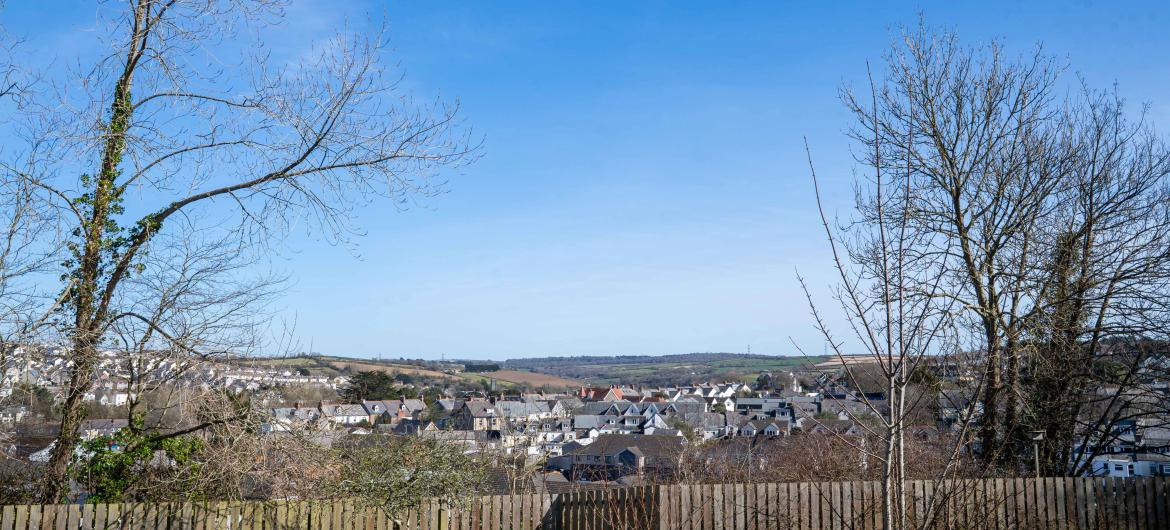 Scenic view of Wadebridge city, featuring a hillside and a wooden fence