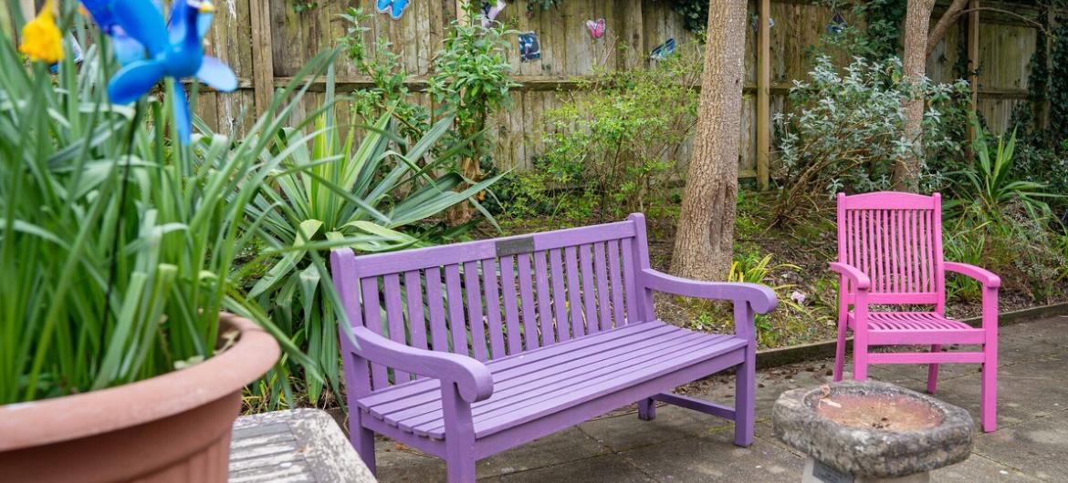 The Trevern, garden. A peaceful garden with colourful seating, blooming flowers, and decorative touches offering a welcoming space for residents to enjoy nature.