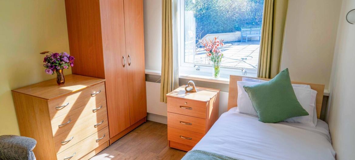 The Woodland, bedroom A calm, welcoming bedroom with soft natural light, a comfortable single bed, and homely wooden furniture. A peaceful space designed for comfort and ease.