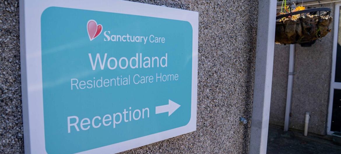 The Woodland, reception sign. Wall mounted signage to The Woodland residential care home