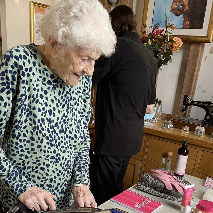 Joan, a resident of Lyons Court Residential Care Home in Chelmsford, helps to fill pre-loved handbags with items for victims of domestic abuse, to support the Love Grace appeal 
