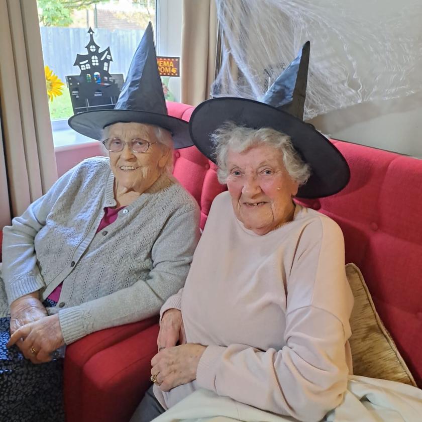 Two female residents wearing witches hats to celebrate Halloween