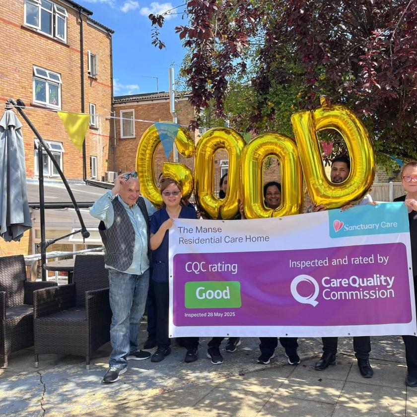 A group of six people stands outside a residential care home, holding large gold balloons that spell out "Good." They are gathered around a banner that reads "The Manse Residential Care Home," along with the CQC rating and inspection details. The setting features greenery and a sunny atmosphere, indicating a positive environment.