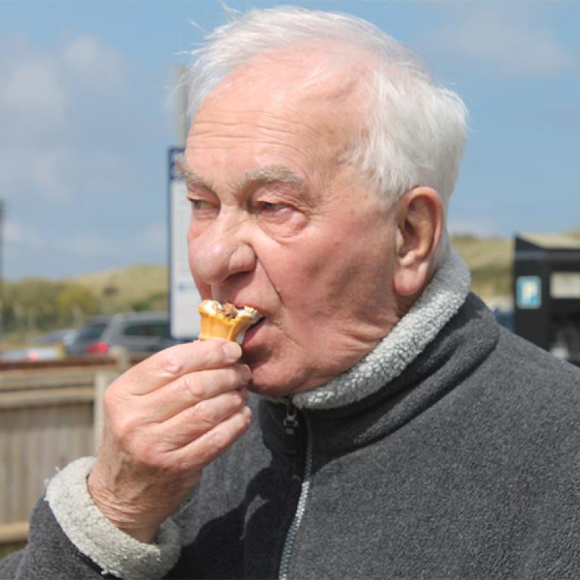 Sanctuary Care resident Ken Andrews eating an ice cream at the beach