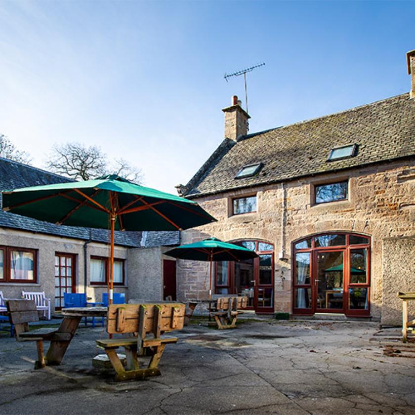 Tyneholm Stables care home entrance with lush green surroundings.